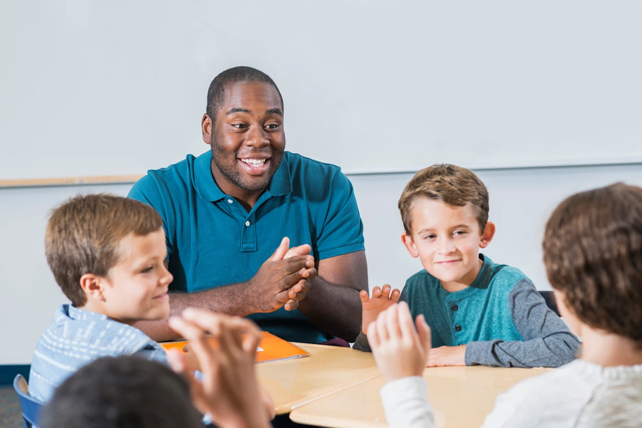 Male teacher with students around a table