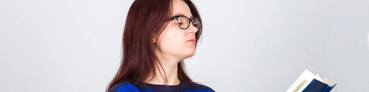 Woman holding a book - issues in education blog - banner image